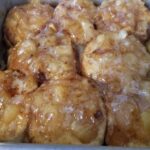 A plate of golden Apple Pie Biscuits drizzled with cinnamon sugar glaze