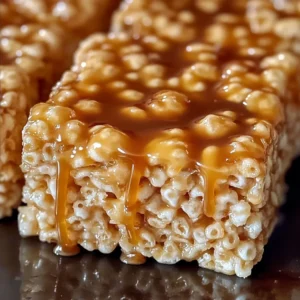 A stack of Salted Caramel Rice Krispie Treats drizzled with caramel and sprinkled with sea salt.