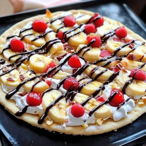 Banana Split Dessert Pizza topped with fresh fruit, whipped cream, and chocolate drizzle