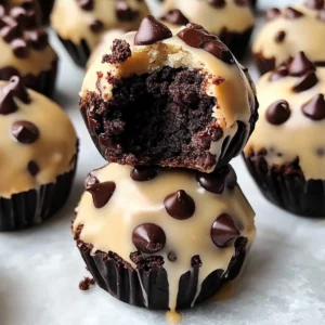 A plate of Chocolate Chip Cookie Dough Brownie Bombs with a bite taken out to show the gooey cookie dough center.