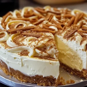 A slice of Cinnamon Roll Cheesecake with swirls of cream cheese frosting on a plate.