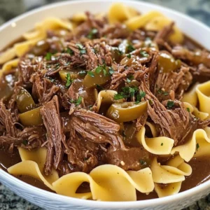 A bowl of Crockpot Mississippi Beef and Noodles with shredded beef and egg noodles