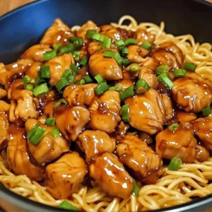 A bowl of One-Pot Honey Garlic Chicken and Noodles garnished with green onions