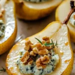 A beautifully plated Blue Cheese Stuffed Pear with honey drizzle and fresh thyme garnish.