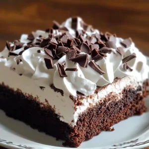 A slice of Brownie Refrigerator Cake with layers of chocolate, cream cheese, and whipped topping