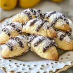 A plate of Cannoli Cookies dusted with powdered sugar and chocolate chips