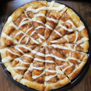 A warm Cinnamon-Sugar Pizza drizzled with icing, served on a wooden board.