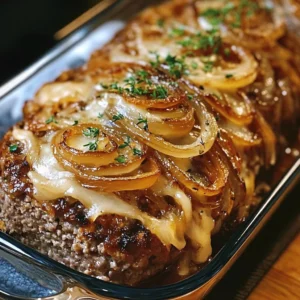 A juicy French Onion Meatloaf topped with melted cheese, served with mashed potatoes