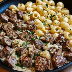 A plate of Garlic Butter Steak Bites & Creamy Parmesan Shells garnished with parsley.