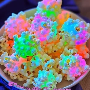A glowing bowl of candy-coated popcorn balls under blacklight.
