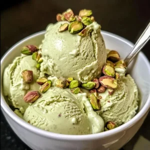 A scoop of High Protein Pistachio Ice Cream garnished with crushed pistachios.