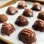 A stack of Homemade Chocolate Turtles showing gooey caramel and crunchy pecans inside.