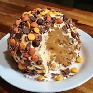 A Reese's Cheese Ball coated in Reese's Pieces and chocolate chips, served with graham crackers.