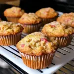 Golden rhubarb muffins with cinnamon sugar topping on a cooling rack