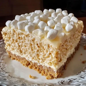A slice of Rice Krispie Treat Cheesecake with a chocolate drizzle and marshmallow topping.