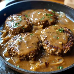 A plate of Salisbury Steak covered in rich onion gravy, served with mashed potatoes