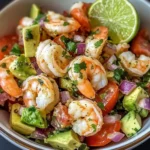 A bowl of Zesty Lime Shrimp and Avocado Salad garnished with fresh cilantro.