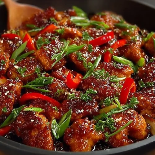 Plate of Asian-Style Crispy Garlic Chicken garnished with herbs