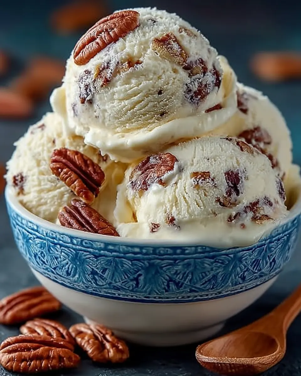 Scoop of homemade butter pecan ice cream with golden roasted pecans in a bowl