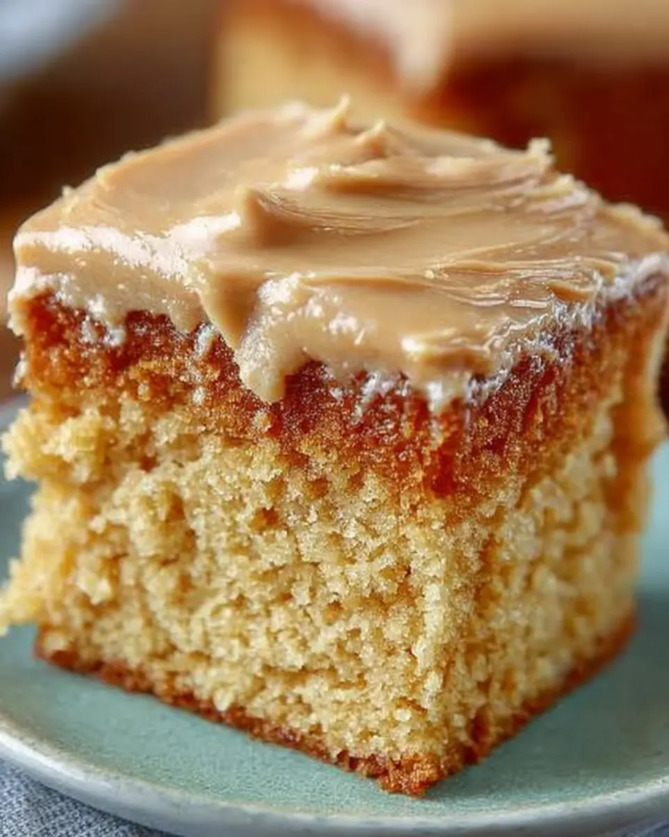 Sliced peanut butter sheet cake with creamy frosting and chopped peanuts on top, served on a baking sheet