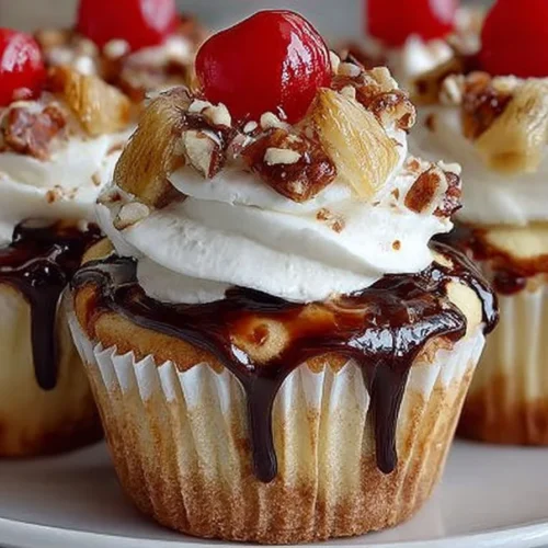 Delicious banana split cupcakes topped with cherries and whipped cream.