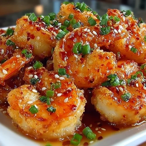 Plate of Bang Bang Shrimp drizzled with spicy mayo and garnished with green onions