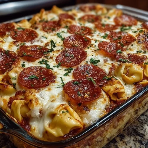 Cheese Tortellini Pepperoni Pizza Casserole topped with melted cheese and fresh ingredients