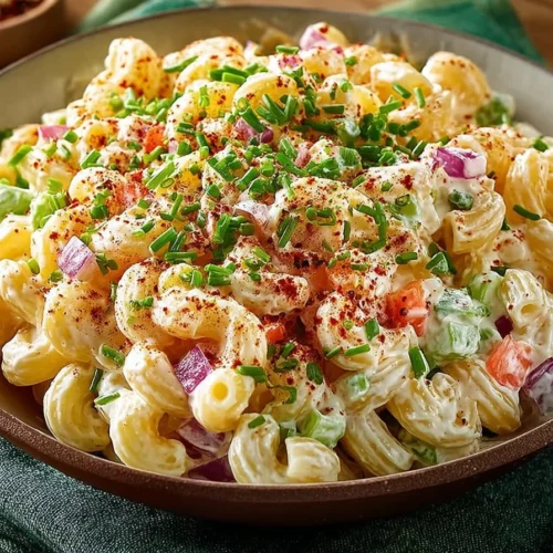 Delicious creamy macaroni salad served in a bowl with veggies