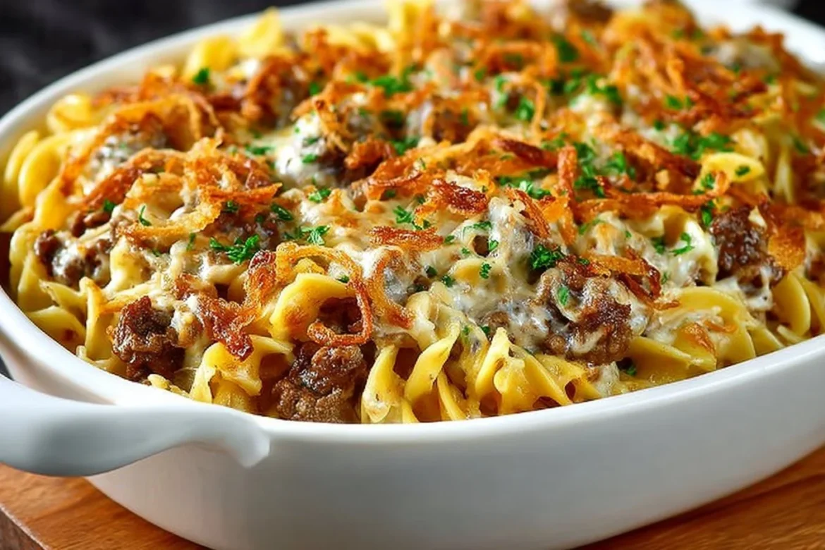 Delicious French onion beef casserole topped with cheese and crispy onions.