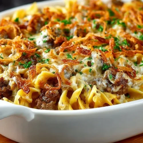 Delicious French onion beef casserole topped with cheese and crispy onions.