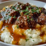 Ground beef and gravy served over mashed potatoes in a delicious dish