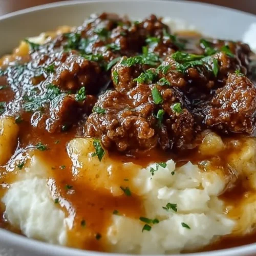 Ground beef and gravy served over mashed potatoes in a delicious dish