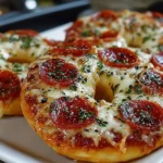 Homemade air fryer pizza bagels topped with cheese and pepperoni.