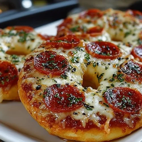 Homemade air fryer pizza bagels topped with cheese and pepperoni.