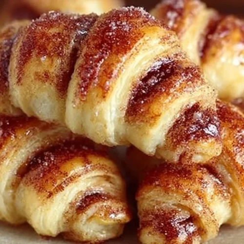 Mini cinnamon crescent rolls fresh out of the oven on a plate.