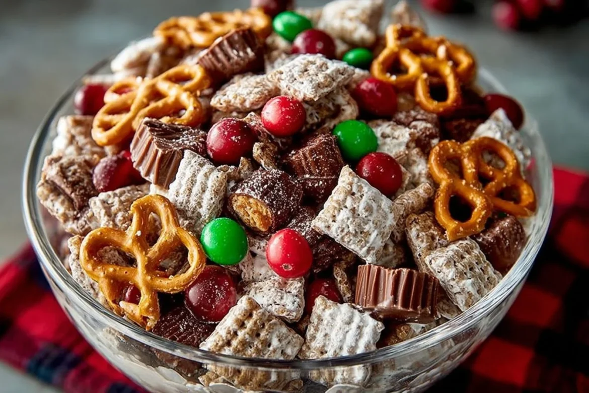 A bowl of Reindeer Chow with colorful ingredients and festive decorations.