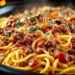 Delicious slow cooker spaghetti casserole served in a bowl with cheese topping