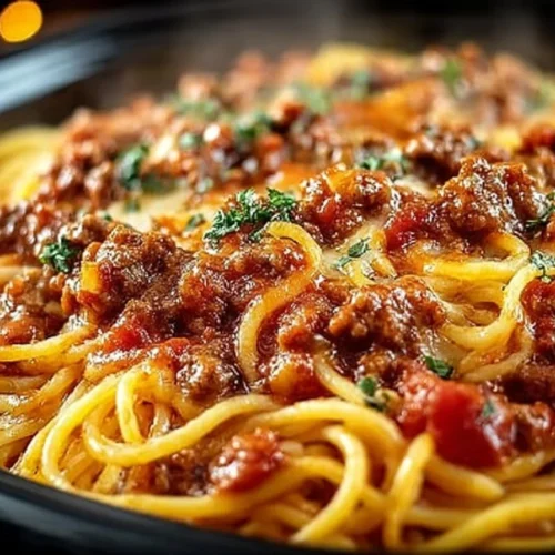 Delicious slow cooker spaghetti casserole served in a bowl with cheese topping