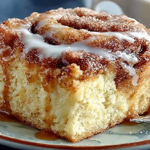 Cinnamon roll coffee cake topped with icing and cinnamon swirl