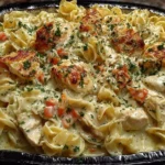 Creamy chicken noodle casserole served in a baking dish with vegetables