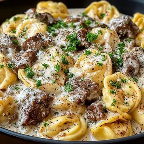 Creamy beef stroganoff tortellini in a savory sauce served in a skillet