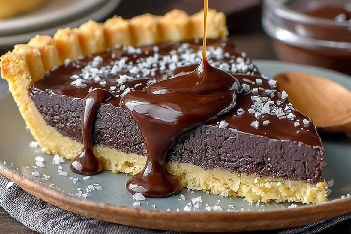 Decadent dark chocolate tart garnished with fresh berries and mint leaves