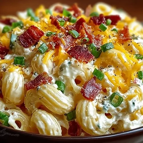 Bowl of jalapeño popper macaroni salad garnished with fresh herbs