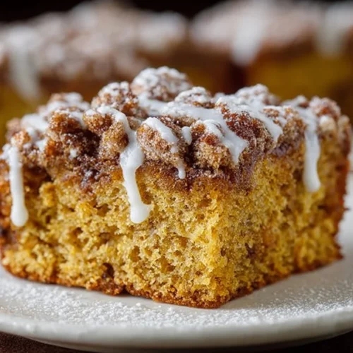 Delicious slice of Pumpkin Spice Coffee Cake topped with cream.