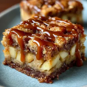 Gooey caramel apple blondies topped with caramel drizzle and apple chunks.