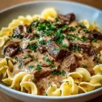 Hearty old-fashioned beef stroganoff served in a bowl with noodles and parsley.