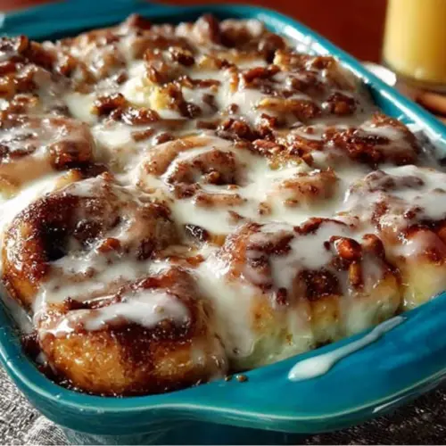 Homemade cinnamon roll casserole fresh out of the oven, topped with icing.