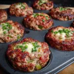 Delicious Meatloaf Muffins served on a plate with fresh herbs.