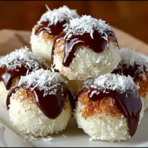 No-bake coconut cream balls arranged on a plate, drizzled with chocolate.