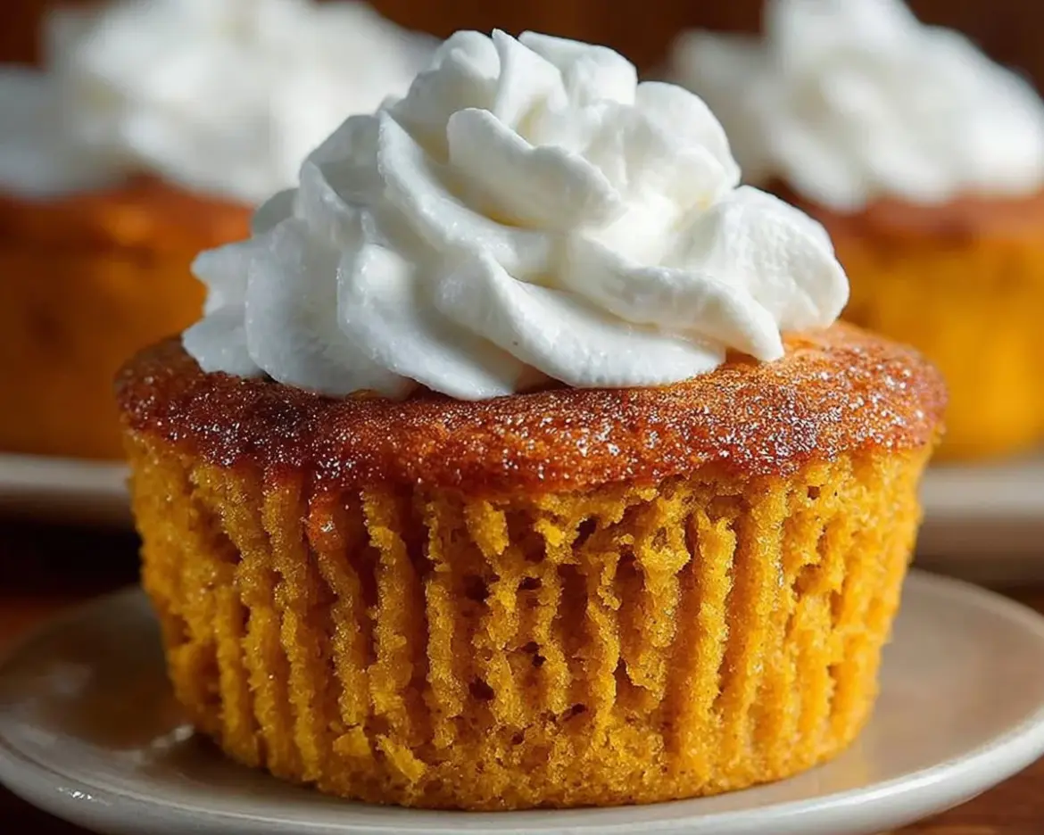 Freshly baked pumpkin muffins with spices and a golden crust.